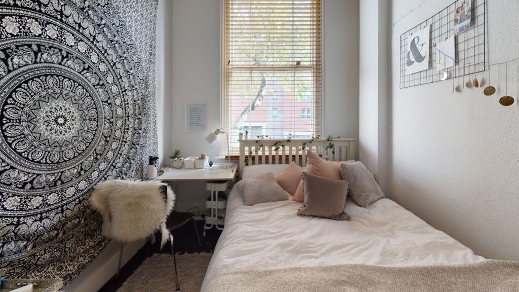 Cozy single bedroom featuring a comfortable bed...