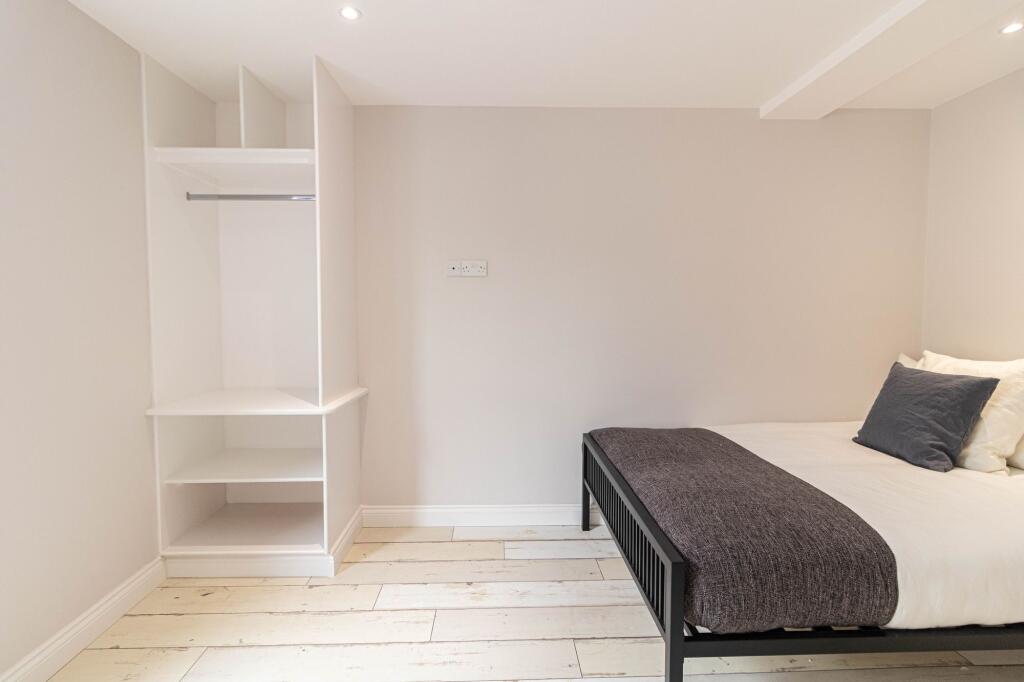 Bright, freshly painted bedroom with built-in o...