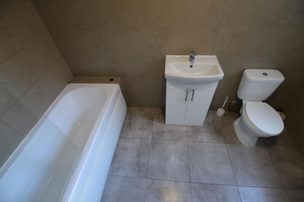 A modern bathroom suite featuring a clean white...
