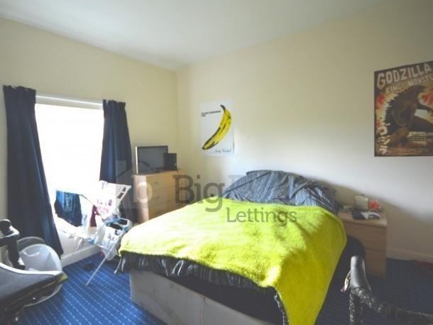 A cozy double bedroom featuring a bed with a br...