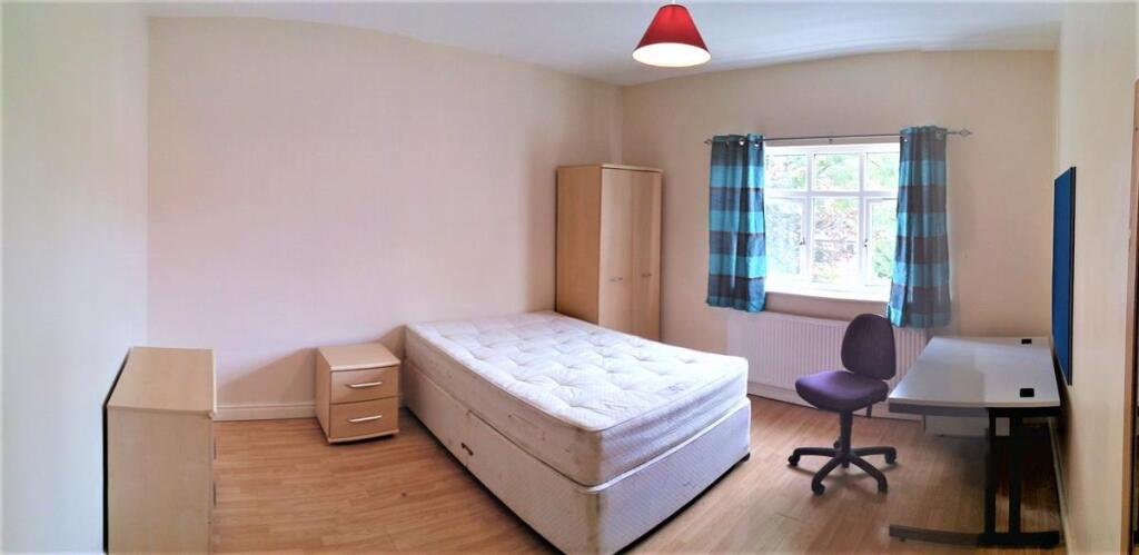A bright and tidy double bedroom featuring a co...