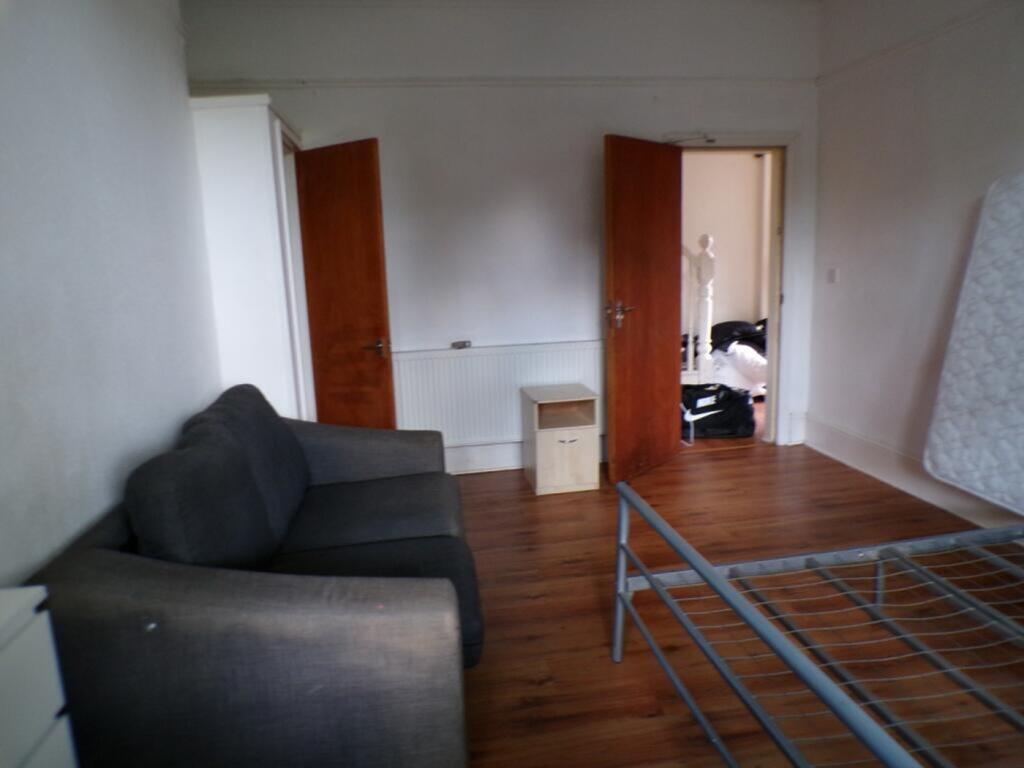 Spacious double bedroom featuring a cozy sofa, ...