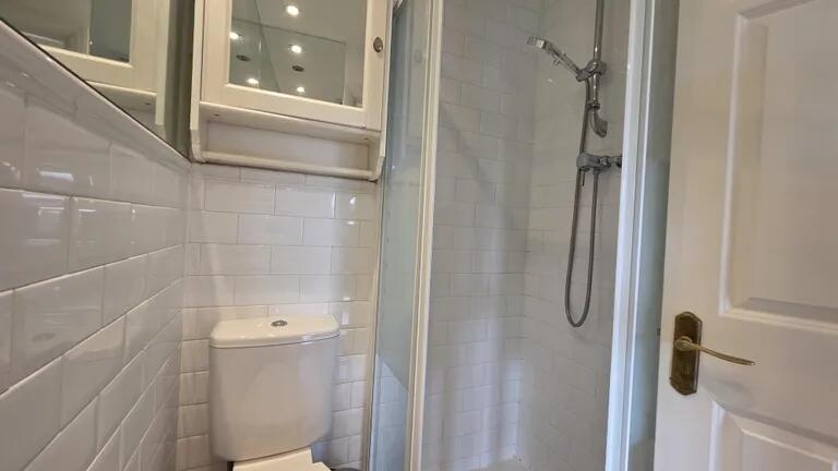 A clean, modern bathroom featuring white tiled ...