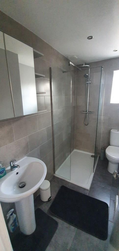 Modern bathroom suite featuring a large walk-in...