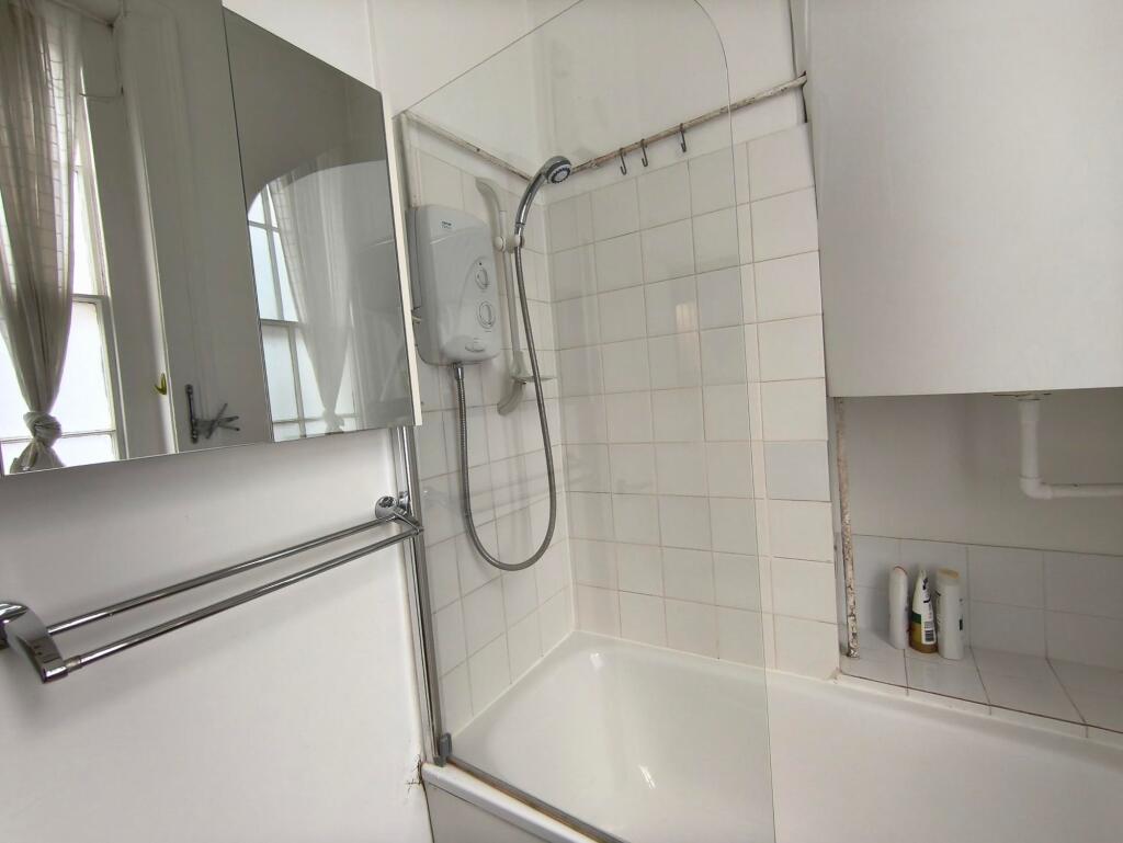 A clean and bright bathroom featuring a shower ...