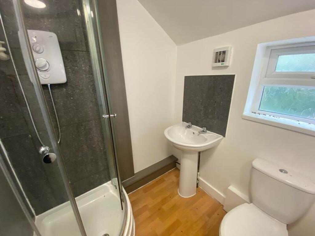 A modern bathroom featuring a shower, sink, and...