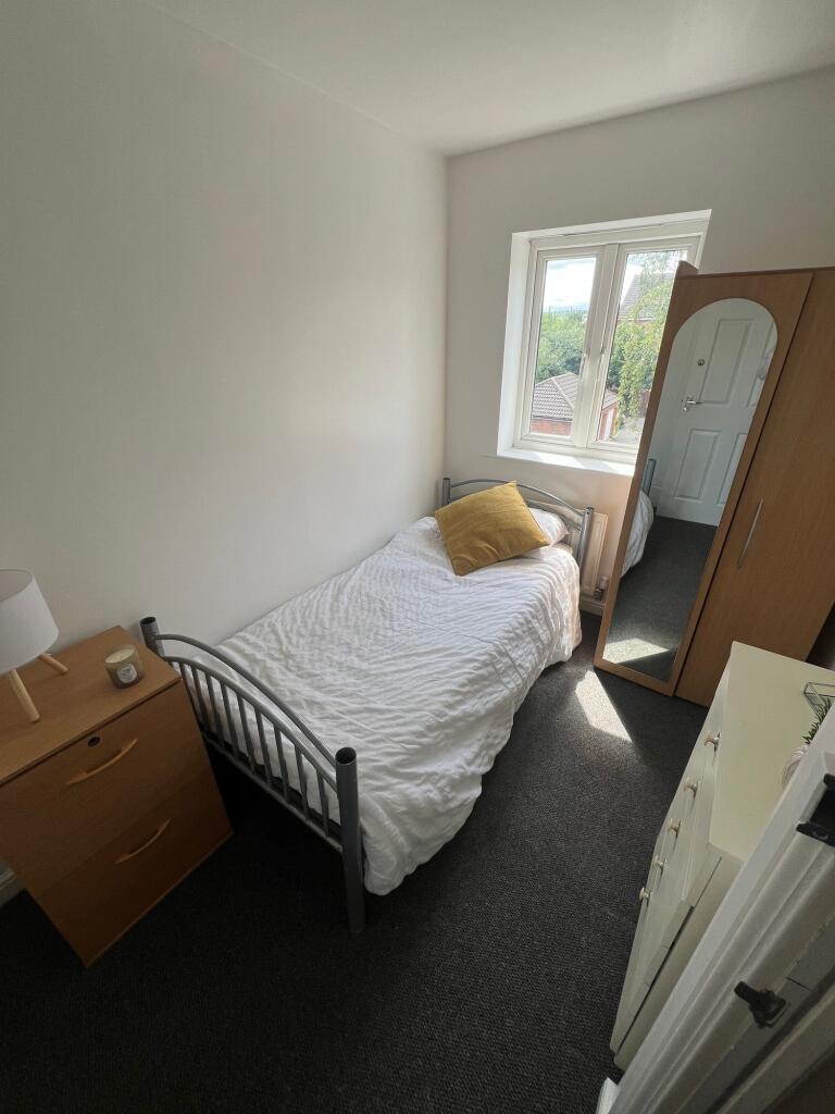A bright and tidy single bedroom featuring a co...
