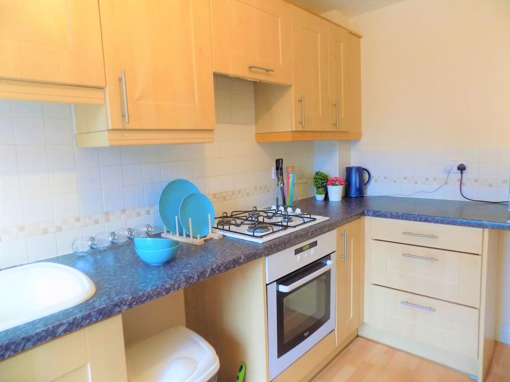 Bright and tidy kitchen featuring modern wooden...