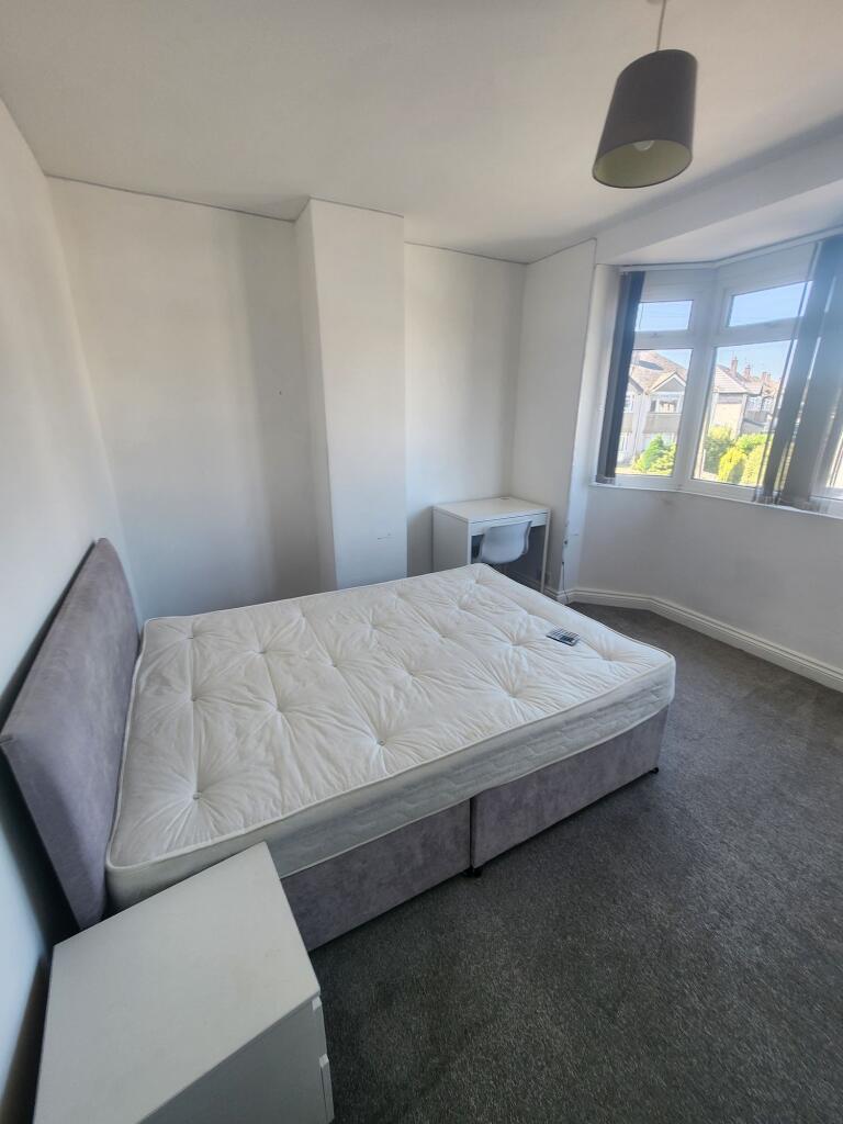 A bright, well-maintained double bedroom with a...