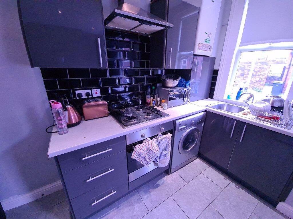 Modern kitchen space featuring sleek dark cabin...