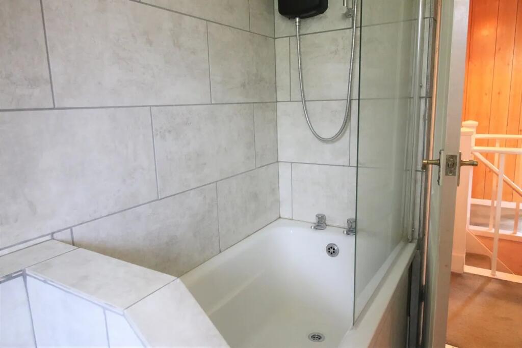 Bright and clean bathroom suite featuring a mod...