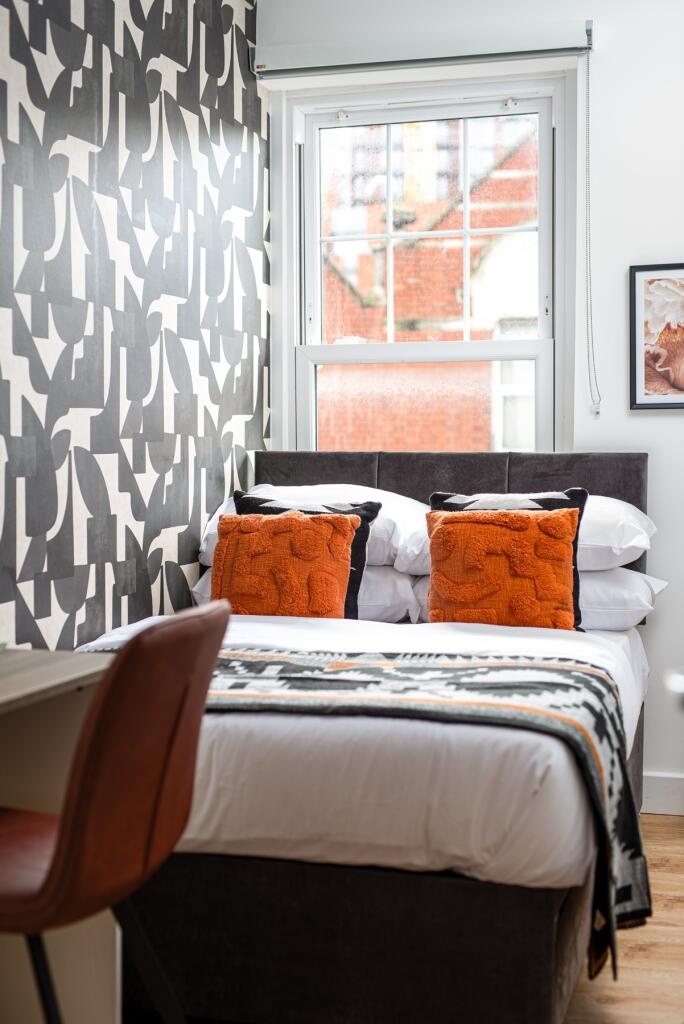 A stylish double bedroom featuring a modern des...