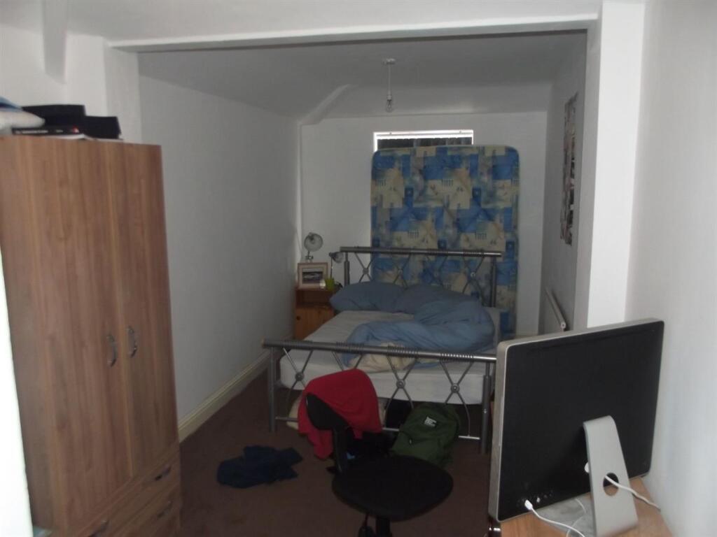Cozy bedroom with a metal bed frame, wooden war...