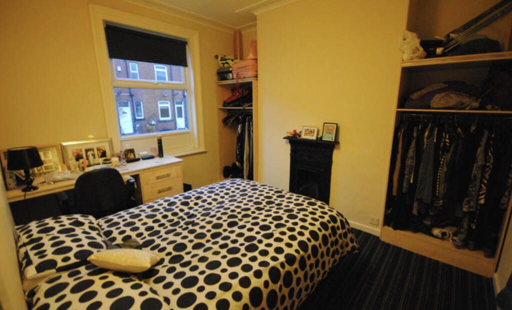 A cozy bedroom featuring a double bed with patt...