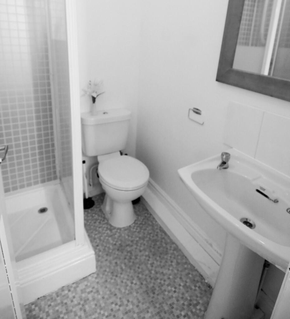 Bright and tidy bathroom featuring a shower cub...
