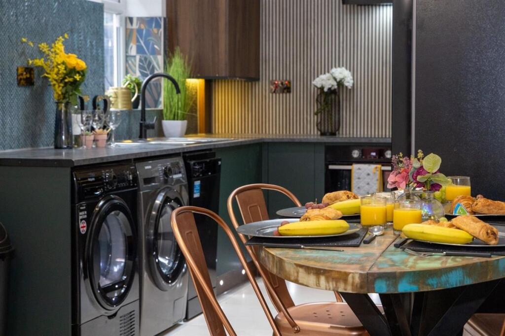 A modern and stylish kitchen featuring sleek bl...