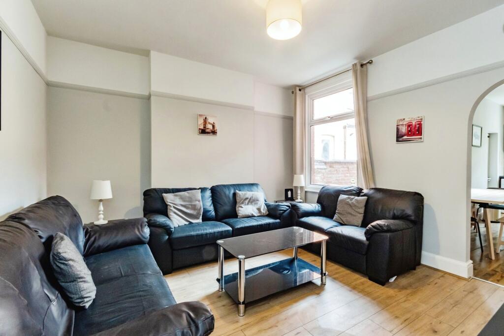 A spacious, well-lit living room featuring thre...