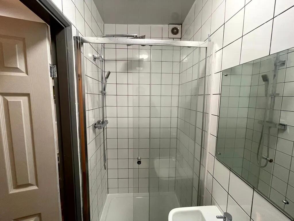 A modern, clean bathroom featuring white tiled ...