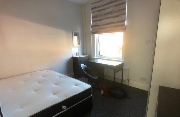 A bright and tidy single bedroom featuring a co...