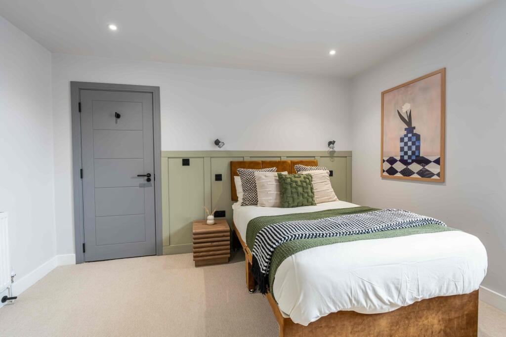 A spacious, well-lit master bedroom with modern...