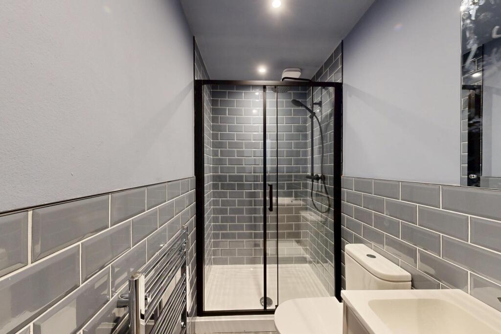 Modern bathroom featuring a spacious shower enc...