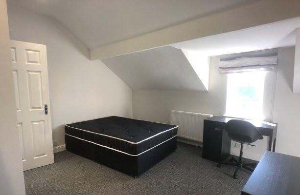 A bright and clean bedroom with a comfortable b...