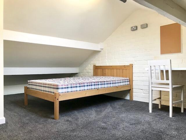 A neat and bright attic bedroom featuring a sim...