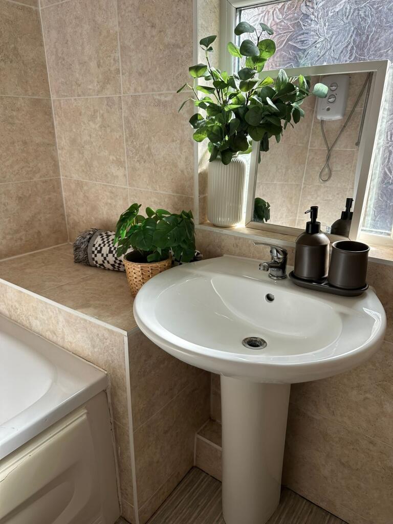 Bright and tidy bathroom featuring a sleek whit...
