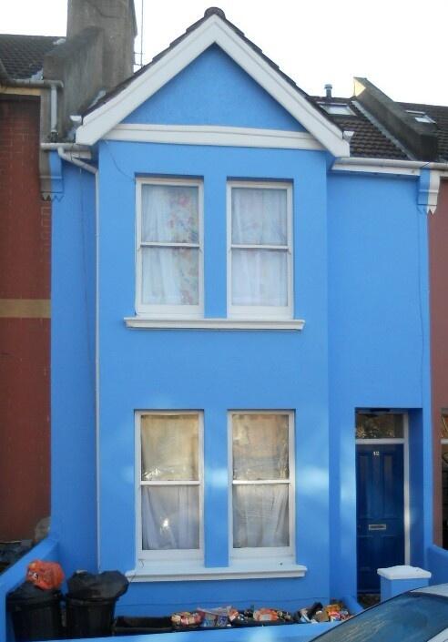 Brightly painted blue terraced house with tradi...