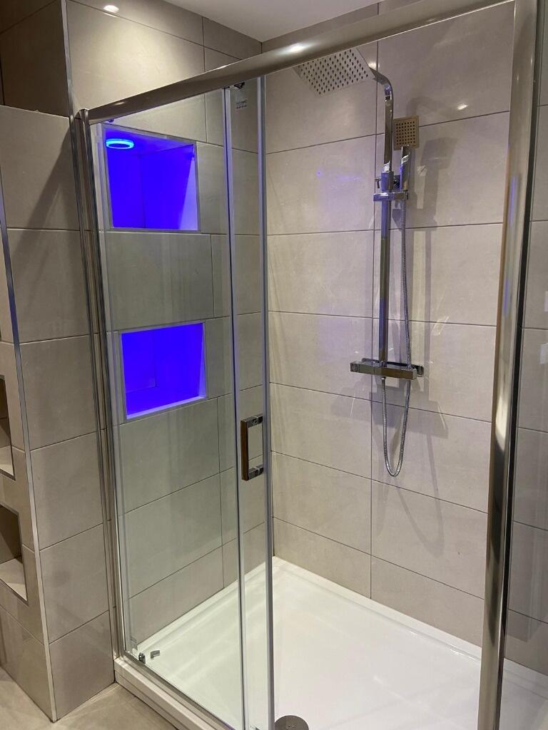 Modern tiled shower enclosure with frameless gl...