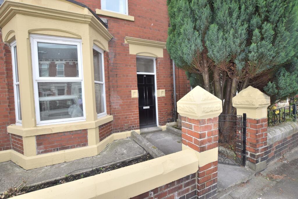 Red-brick terraced house with bay window, black...