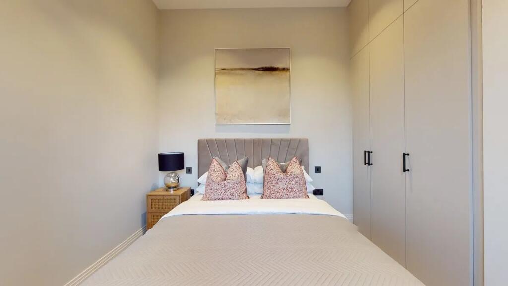 A neatly arranged double bedroom featuring a co...