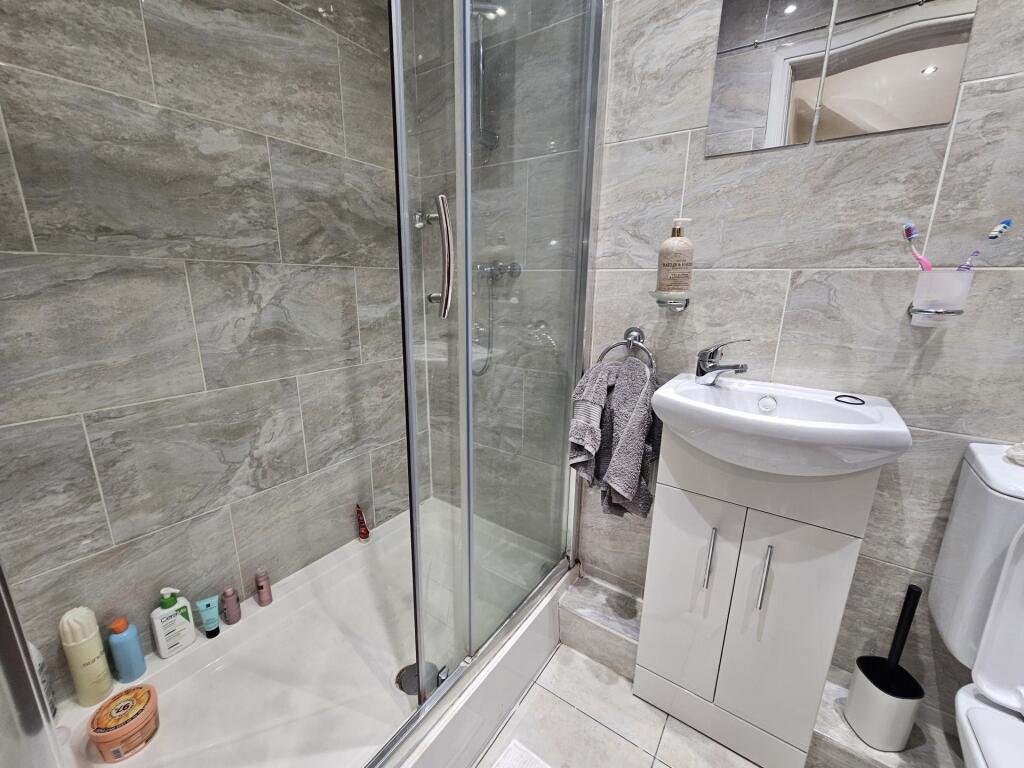 A modern bathroom featuring a shower enclosure,...