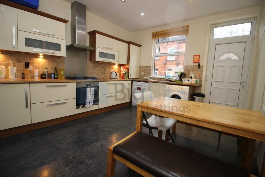A modern kitchen with cream cabinets, a wooden ...