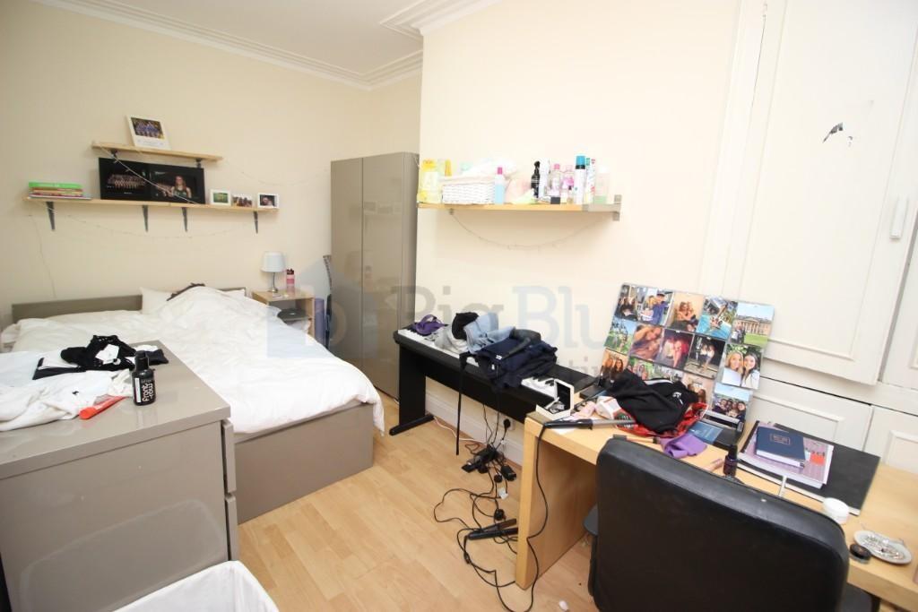 Cozy single bedroom featuring a neatly made bed...