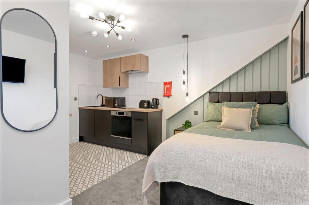 A modern, well-lit living area with a cozy sofa...