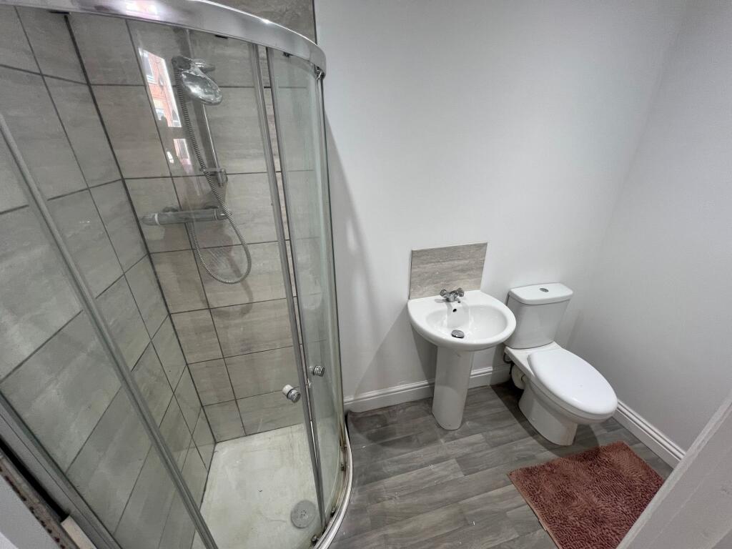 Modern bathroom featuring a curved glass shower...