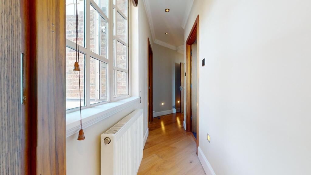A bright and inviting hallway featuring polishe...
