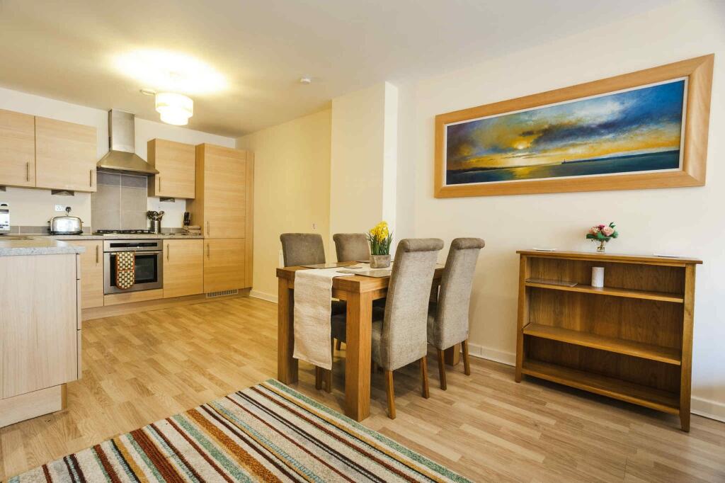 A modern kitchen and dining area featuring ligh...