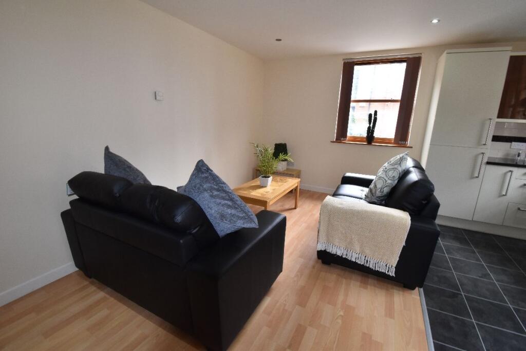 A cozy living room featuring two black leather ...
