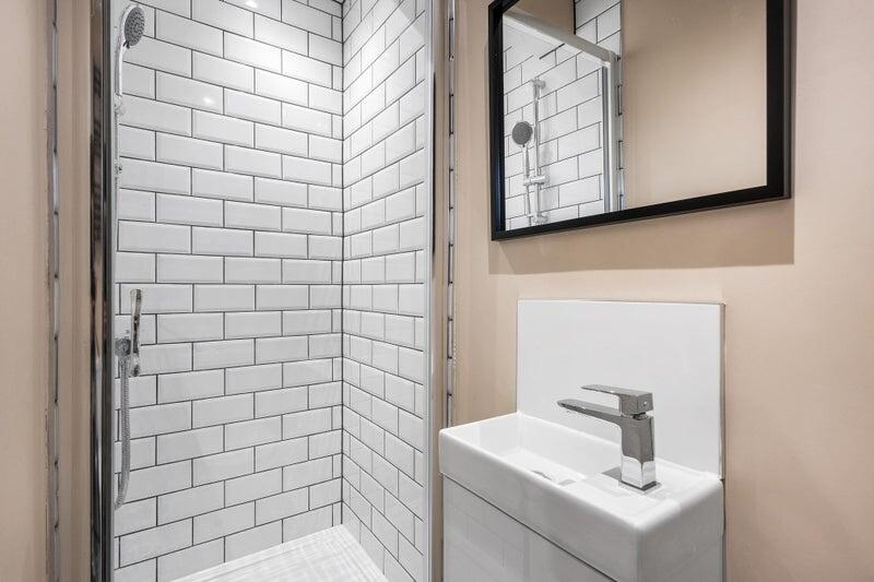 Modern bathroom featuring sleek white subway ti...