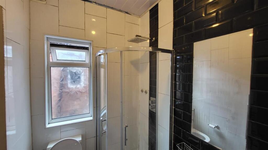 A clean and modern bathroom with a large shower...