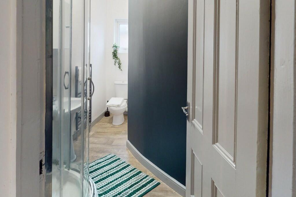 A modern bathroom featuring a curved glass show...