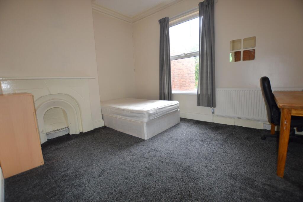 A simple and tidy single bedroom featuring a co...