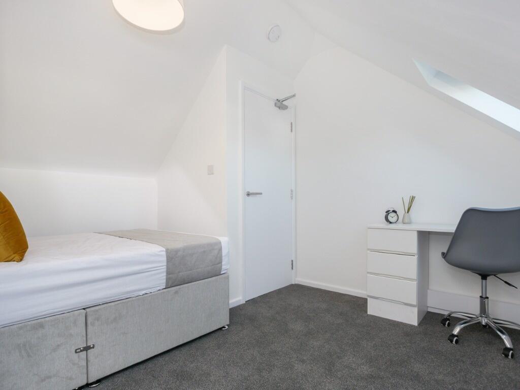 A neat and modern single bedroom featuring a co...