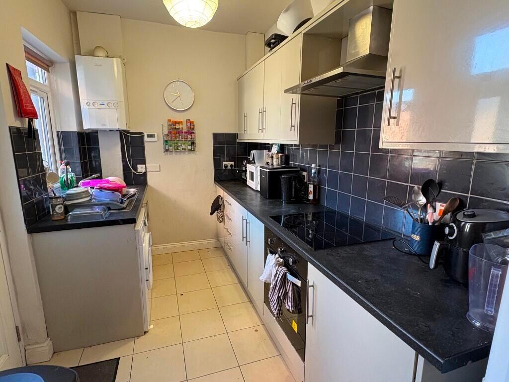 Modern kitchen featuring sleek black countertop...