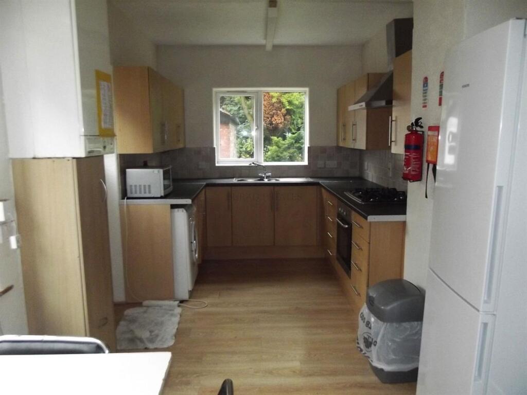 Bright galley-style kitchen with wood-effect ca...
