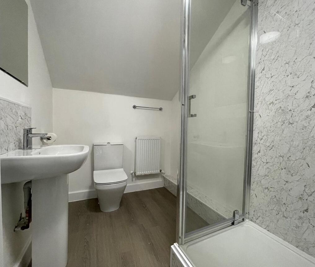 A clean and bright bathroom with a modern showe...