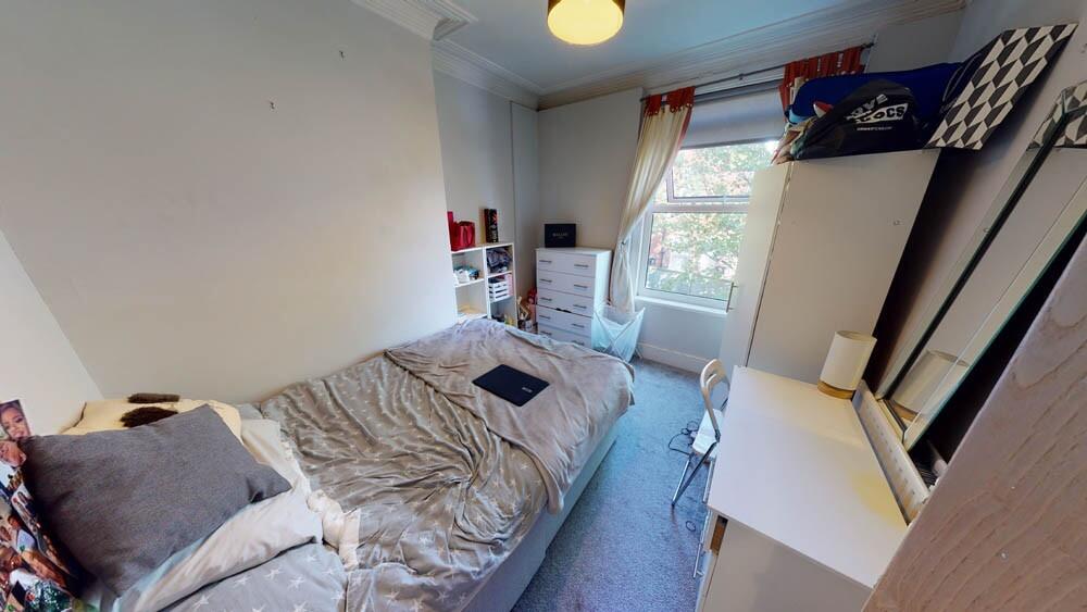 A cozy single bedroom featuring a comfortable b...