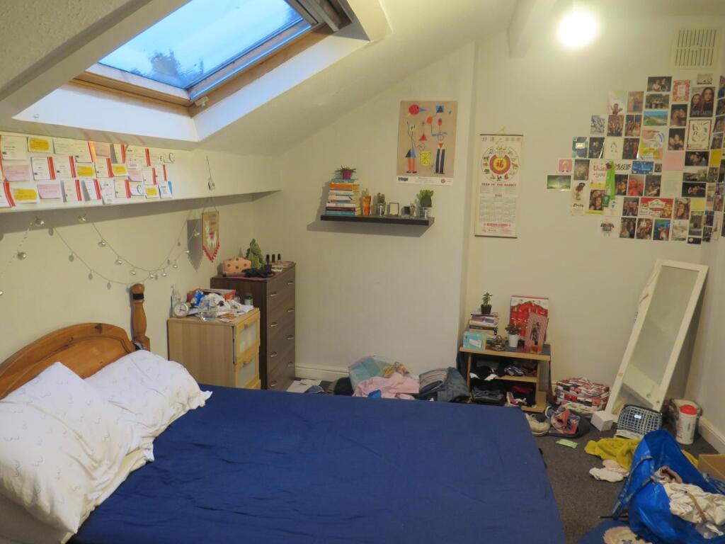 Brightly lit attic double bedroom with a skylig...